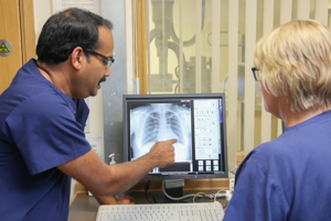 Male and female healthcare professionals looking at a chest x-ray